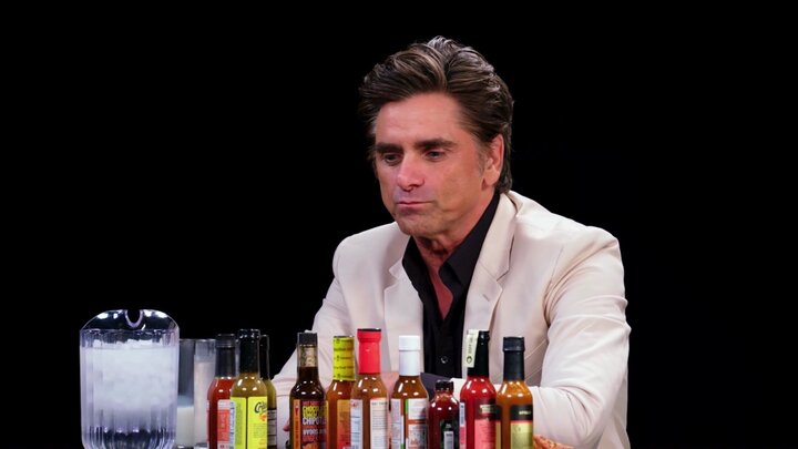 John Stamos Falls Out of His Chair While Eating Spicy Wings